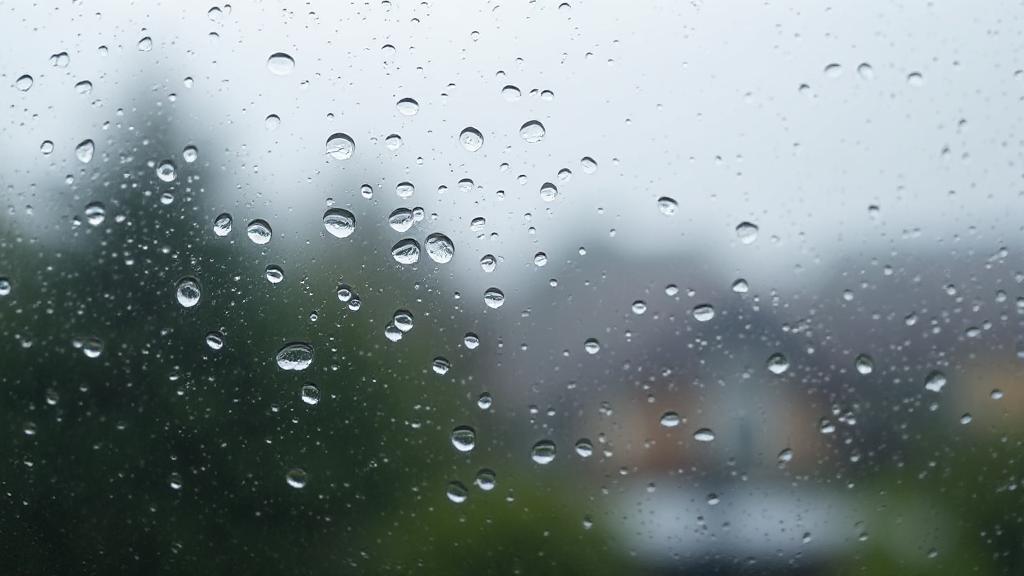 A close-up image of a foggy window with condensation droplets, illustrating moisture buildup inside a home.